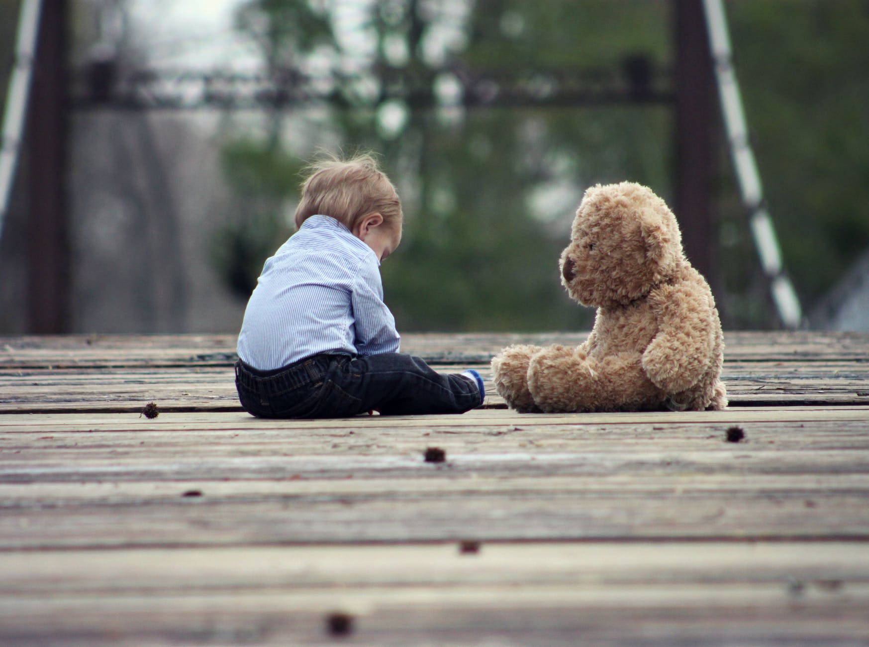 help your child overcome anxiety boy sitting with brown bear plush toy on selective focus photo