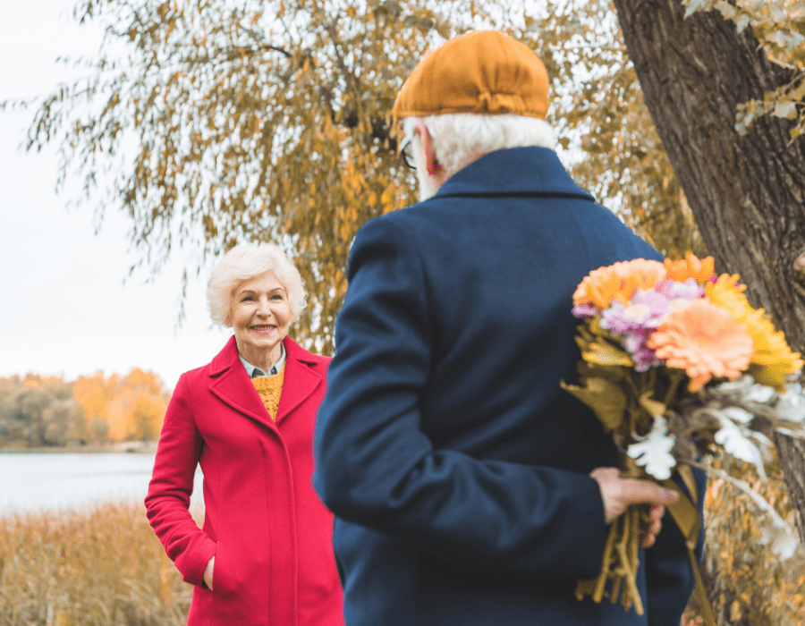 Older-man-hiding-flowers-from-older-woman-more-companionship-in-marriage