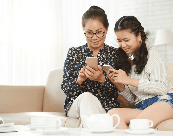 Mom and Daughter looking at cell phone mom and daughter date ideas