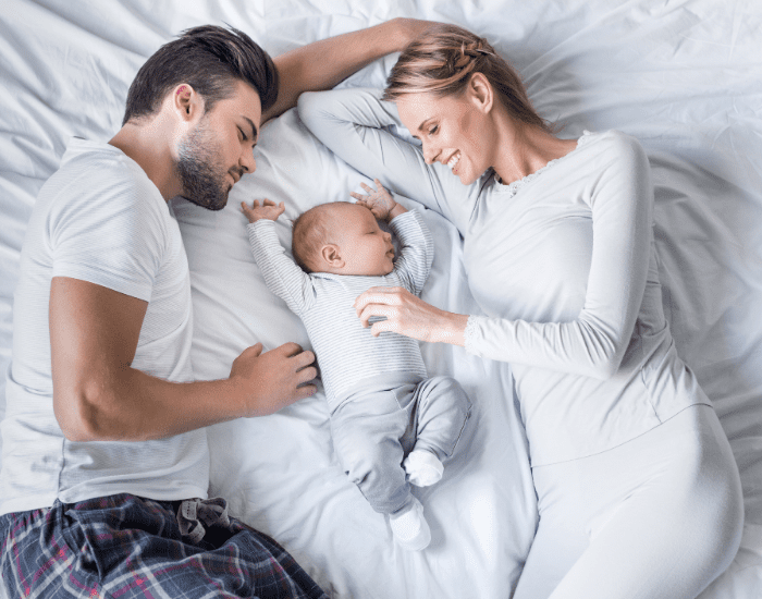 Mom Dad and Baby Laying Down Best Parenting Apps Article