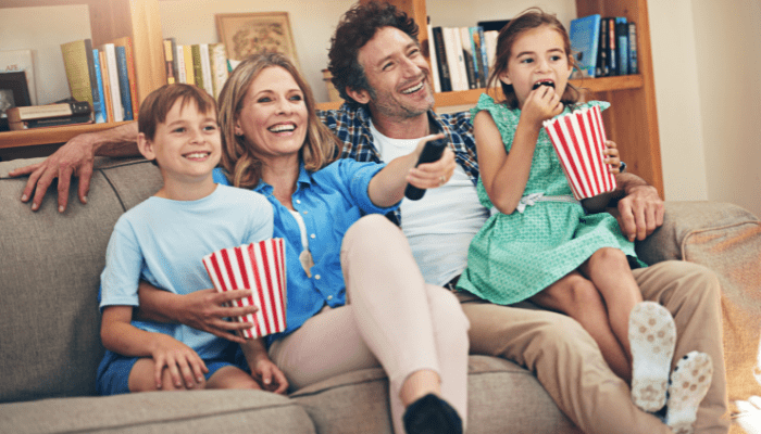 ideas for family movie night family watching movie eating popcorn