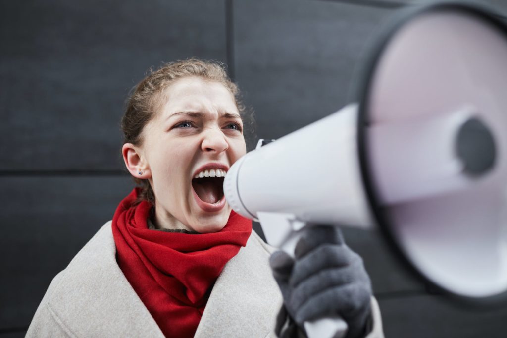 alternative to yelling a woman in red scarf holding a megaphone