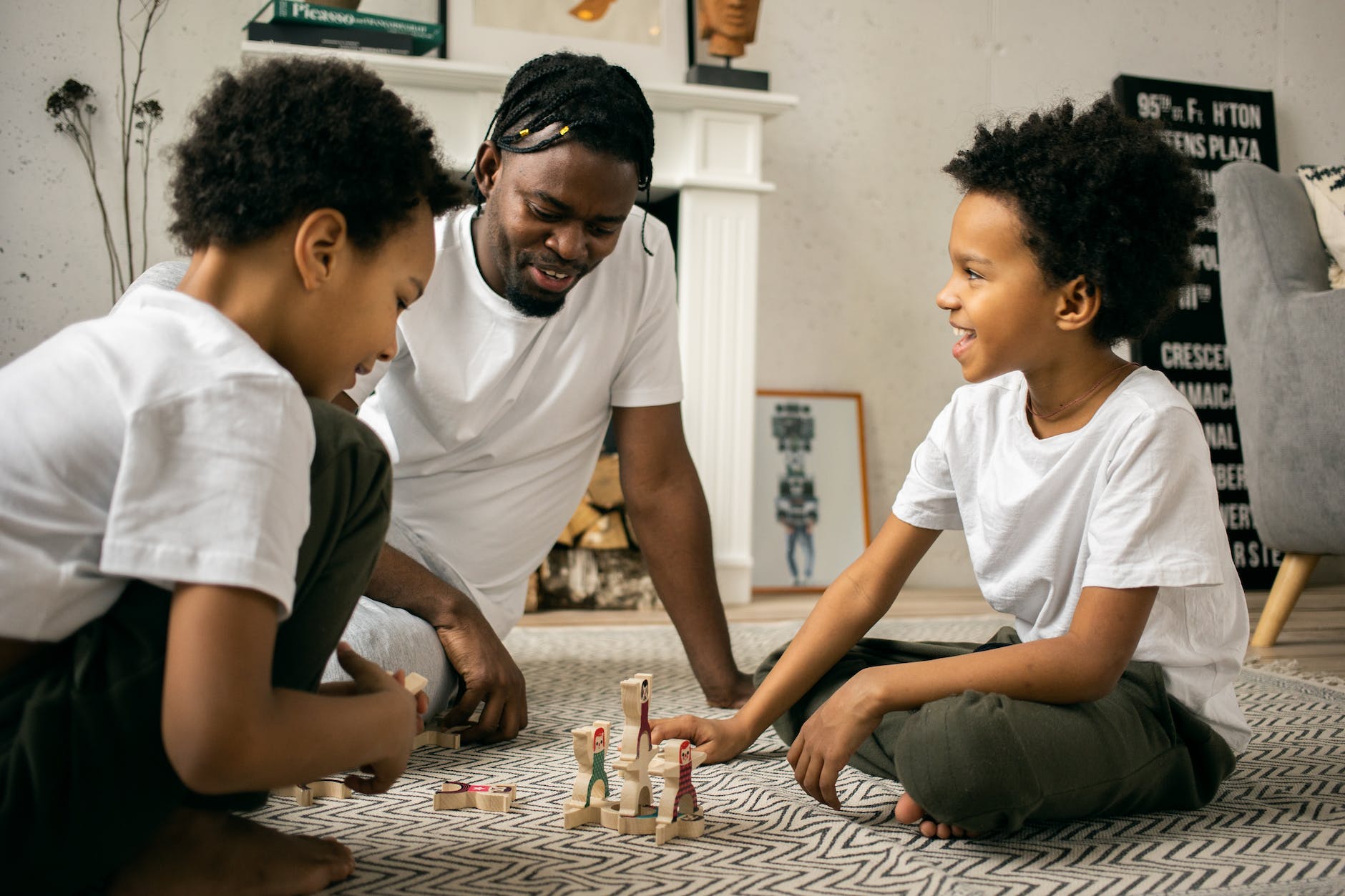 black man playing with children in living room father son activities 