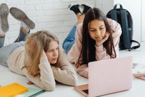 girls using a pink laptop