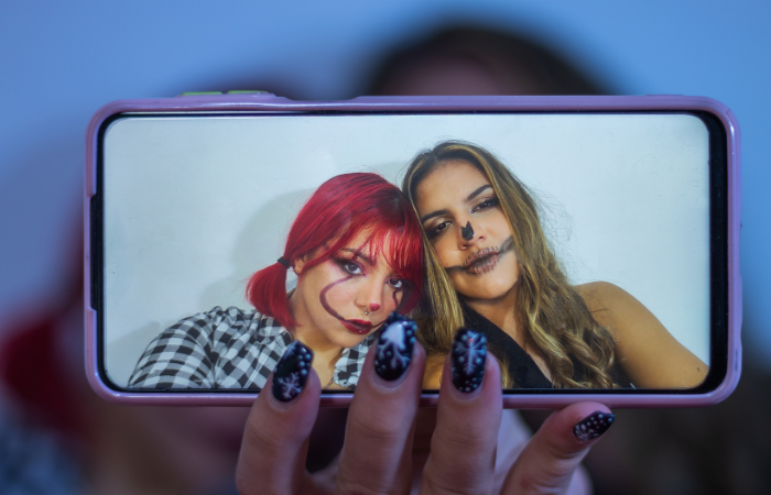 two girls with painted faces taking a selfie