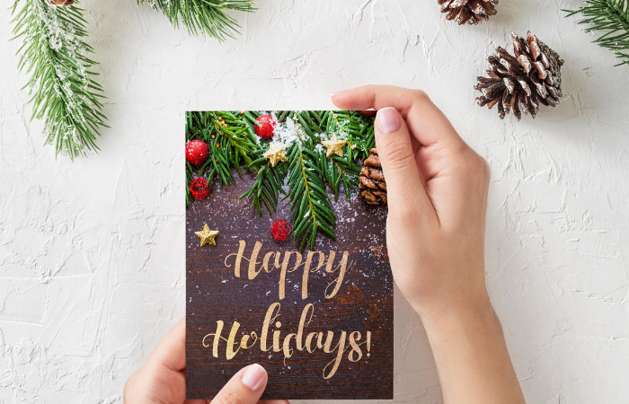person holding a happy holidays greeting card
