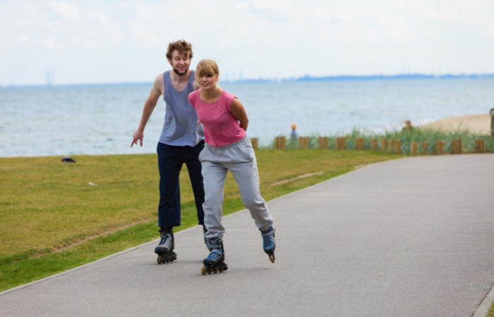 ccouple roller blading on a sidewalk - fun date ideas for teenagers