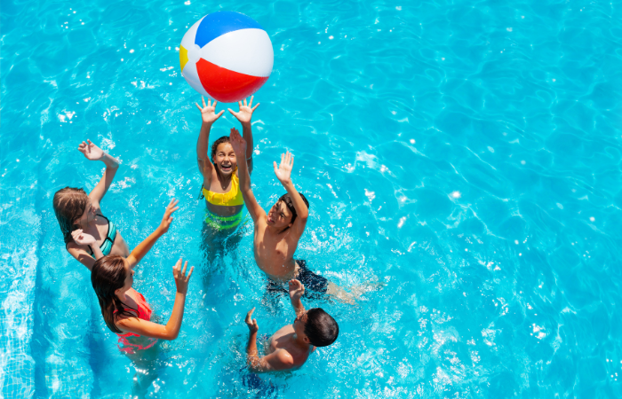 teens playing with a beach ball in a pool. fun date ideas for teens