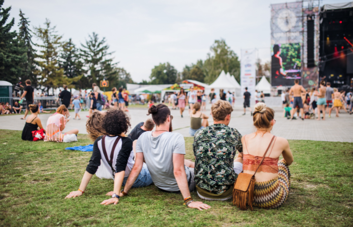 teens sitting on the grass at a music festival