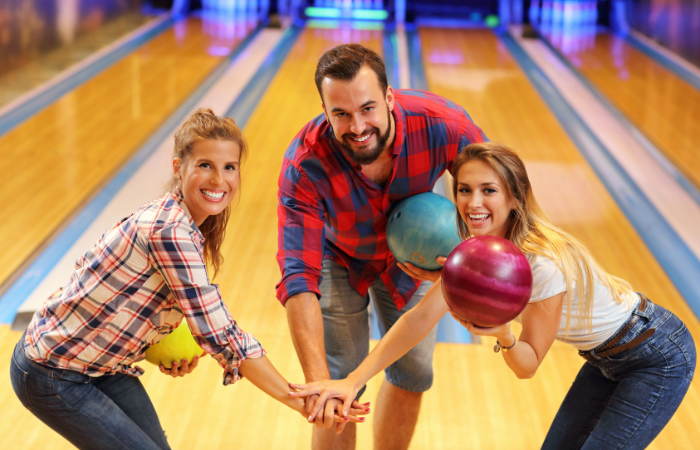 wacky ways to bowl man and 2 women holding bowling balls