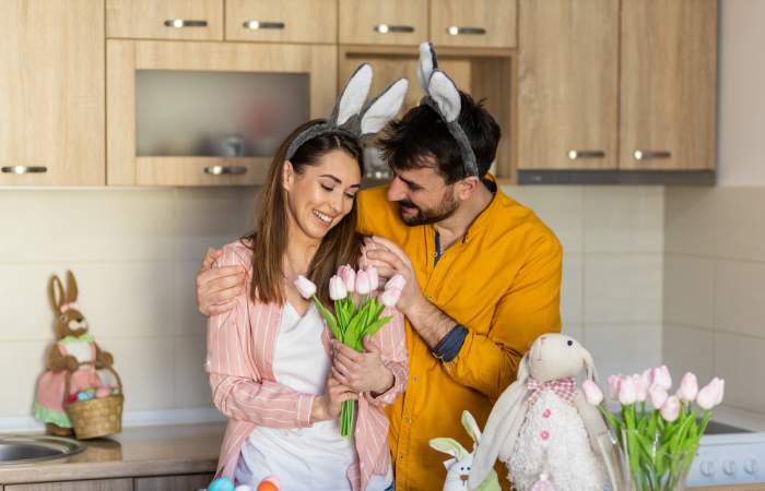 man and woman wearing bunny ears and woman holding pink tulips