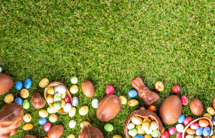 adults clues for easter scavenger hunt - chocolate eggs and bunnies scattered in the grass