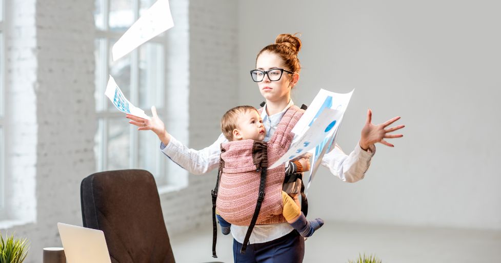 mom holding baby throwing papers 