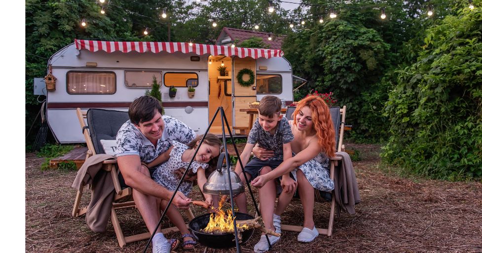 family camping roasting hot dogs