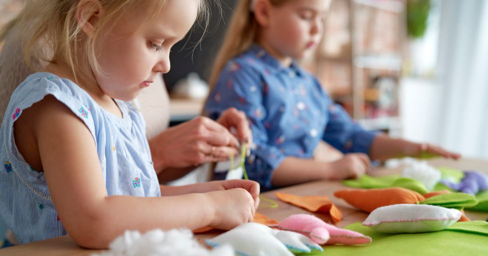 two girls making stuffed animals