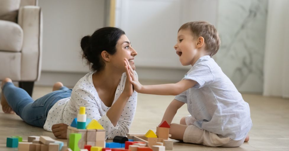 mom playing blocks with little boy