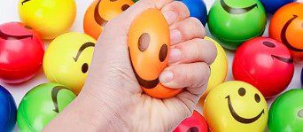 various colored stress balls with smiley faces on them