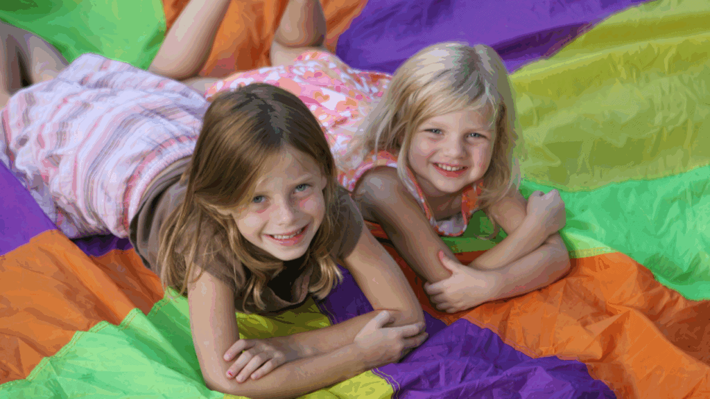 cousin trip ideas two girl laying on a parachute cousins camp ideas