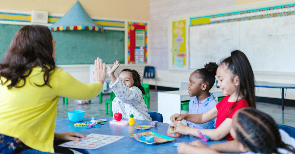 morning routine kindergarten young children in a classroom sitting around a table
