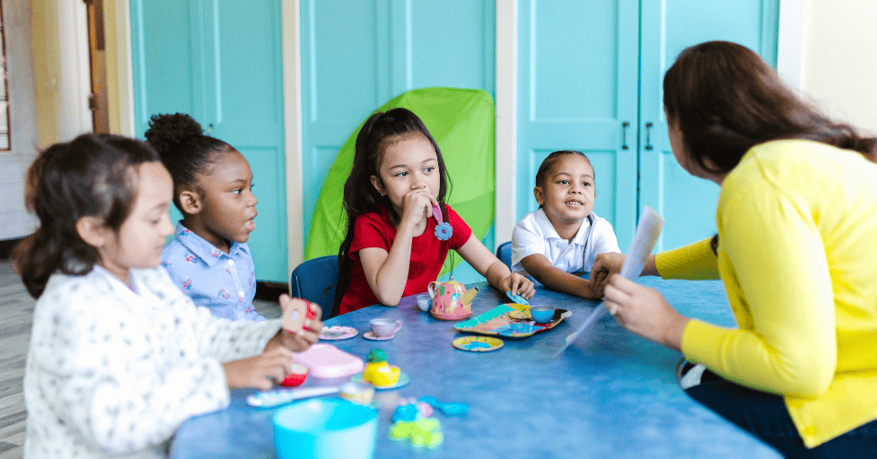 morning routine kindergarten young children in a classroom sitting around a table